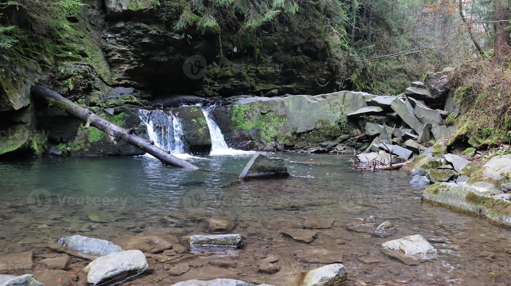 cascadas en un pequeño cañón con paredes de piedra. hermosa cascada en las montañas. río en los Cárpatos en el bosque de otoño de montaña. vista panorámica, el movimiento del agua. foto