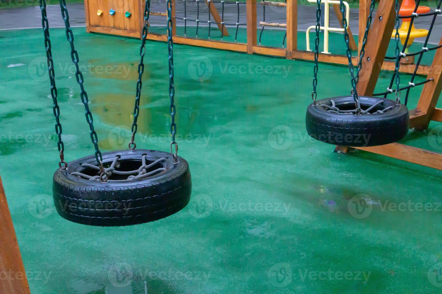 A courtyard of high-rise buildings with a modern and large playground made of wood and plastic on a rainy summer day without people. Empty outdoor playground. A place for children's games and sports. photo