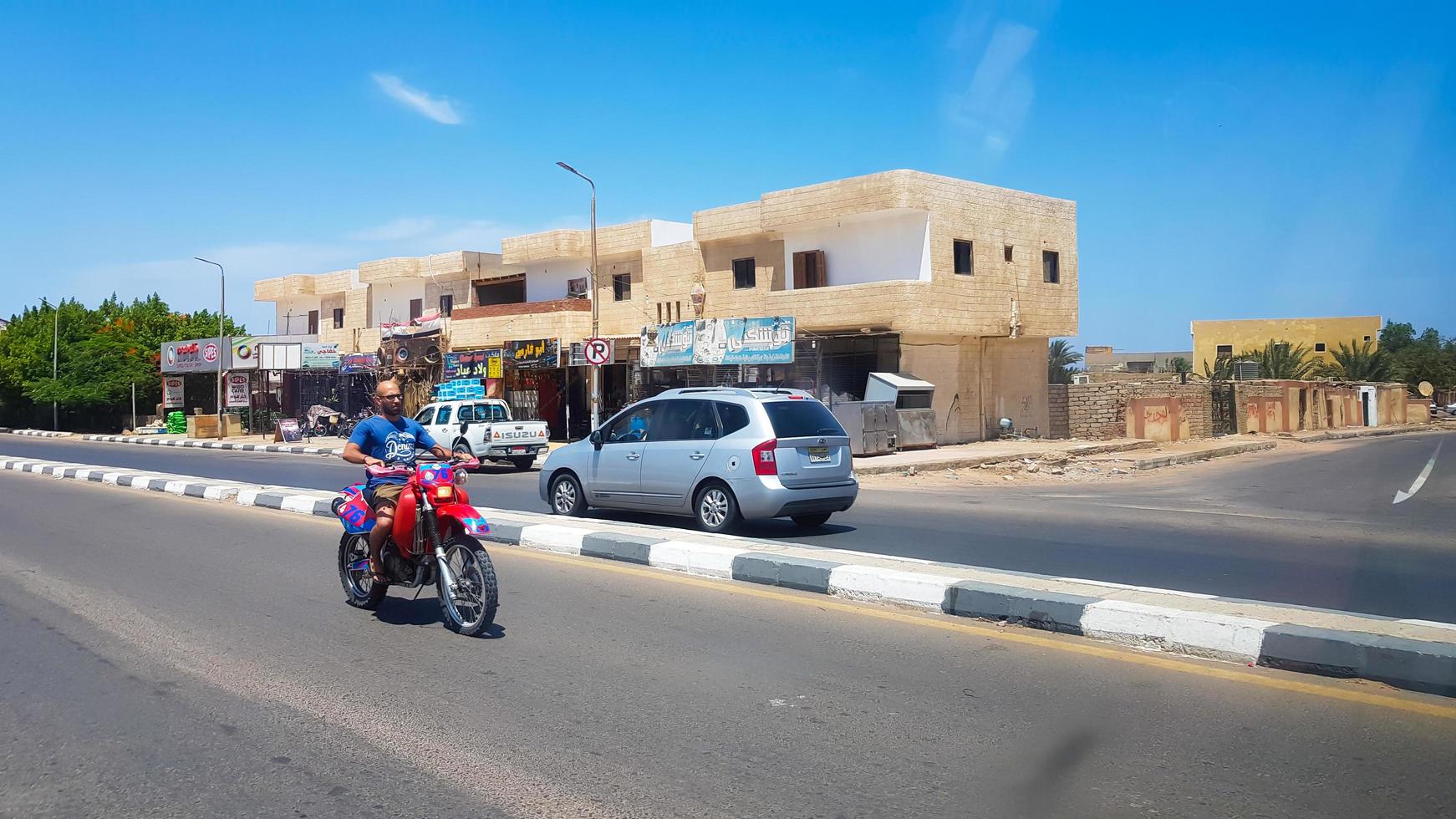 Egipto, Dahab - 20 de junio de 2019. Un árabe en scooter por una de las calles de Dahab. calle del desierto. edificios residenciales egipcios. la ciudad de dahab. foto