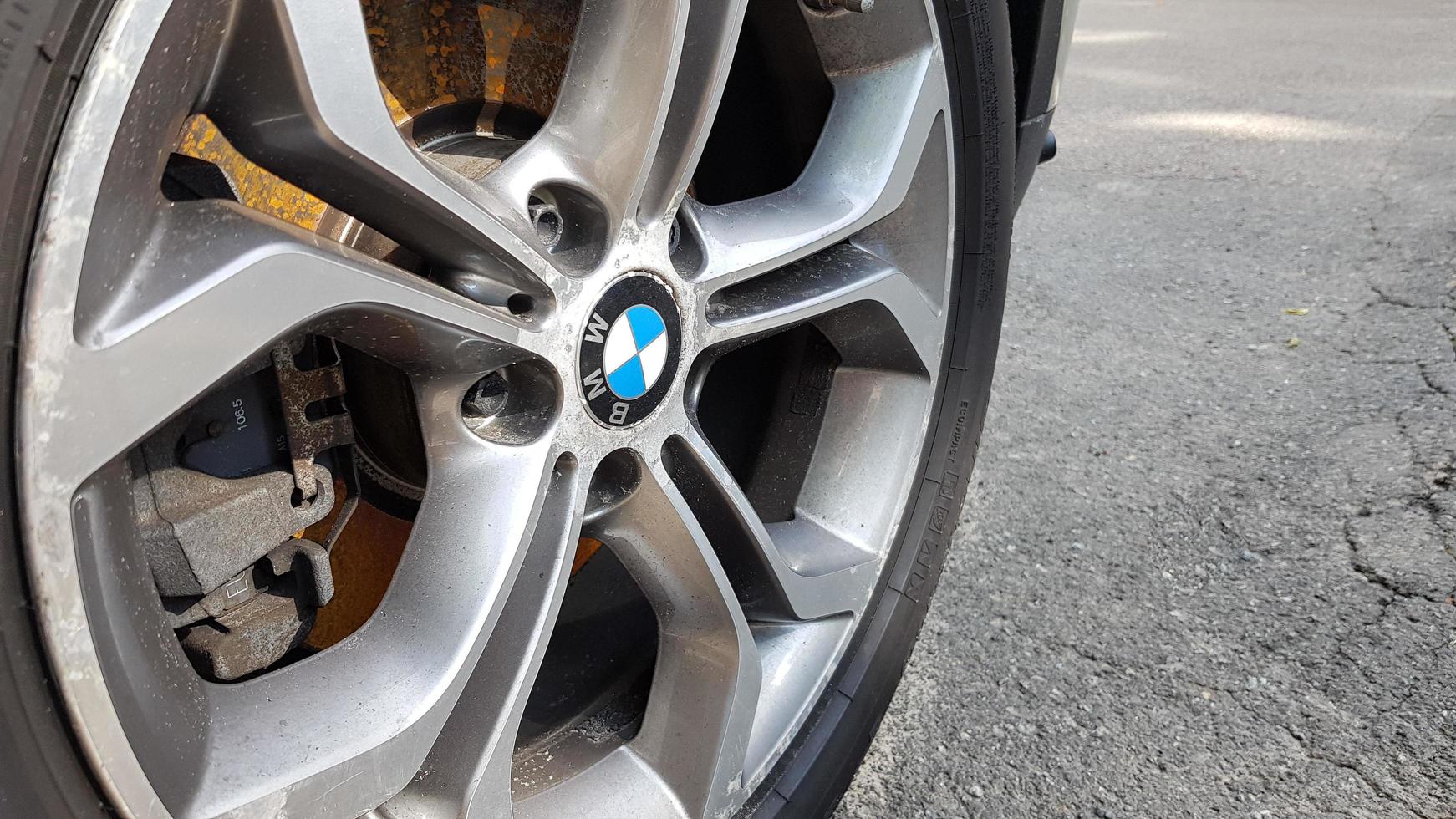 Ukraine, Kiev - August 28,2019. Original BMW alloy wheel dirty and scratched with tires on a car close-up photo