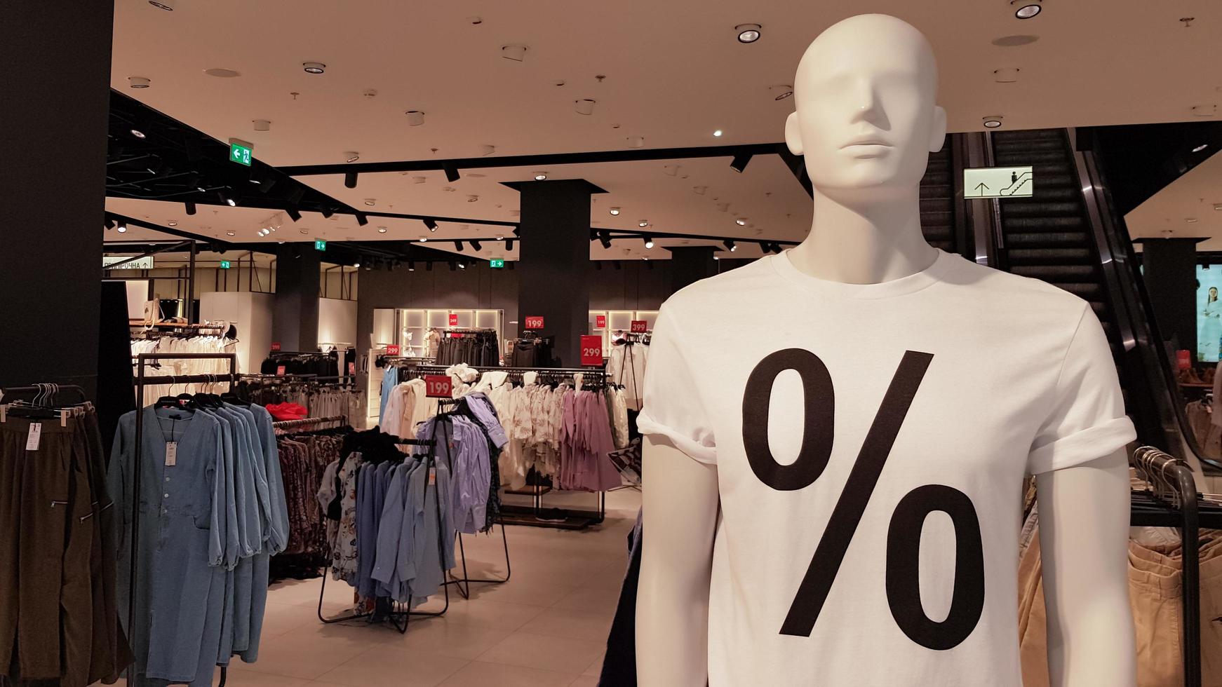 Mannequins wearing white T-shirts with a percent sale sign in a shopping mall Promotion, advertising, shopping and black friday concept. Ukraine, Kiev - September 1, 2020. photo