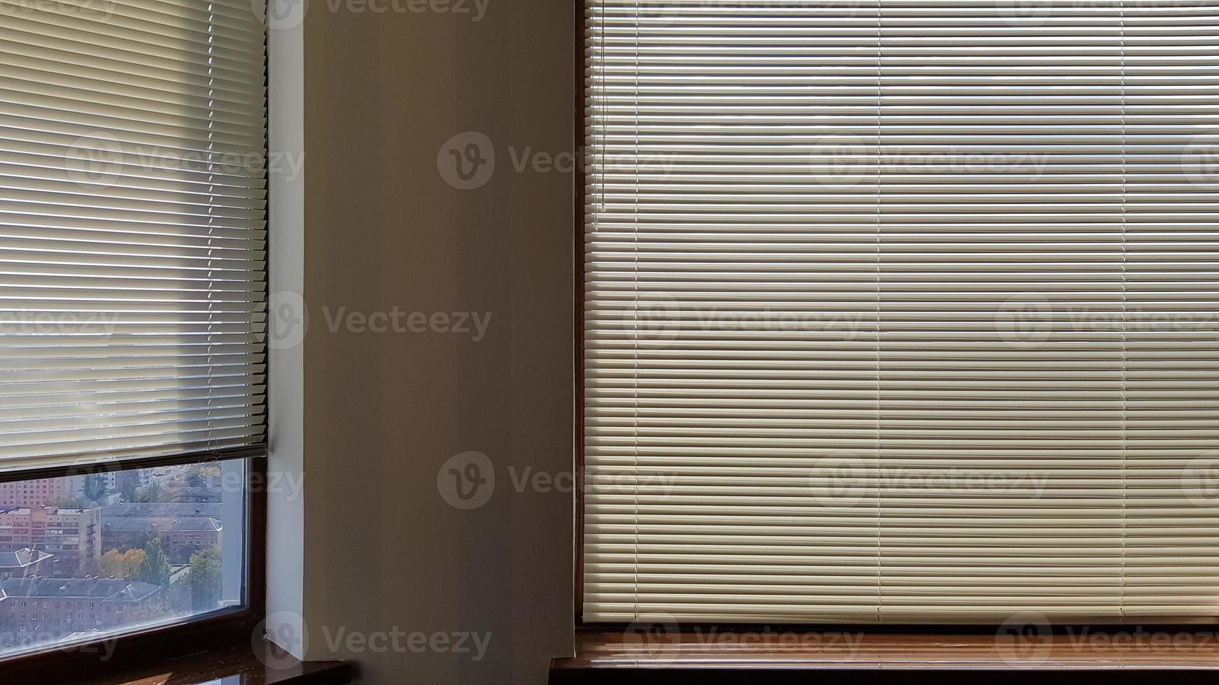 Las persianas están unidas a la ventana para proteger del calor y la luz solar en el interior. las persianas enrollables de la casa captan la luz del sol. foto