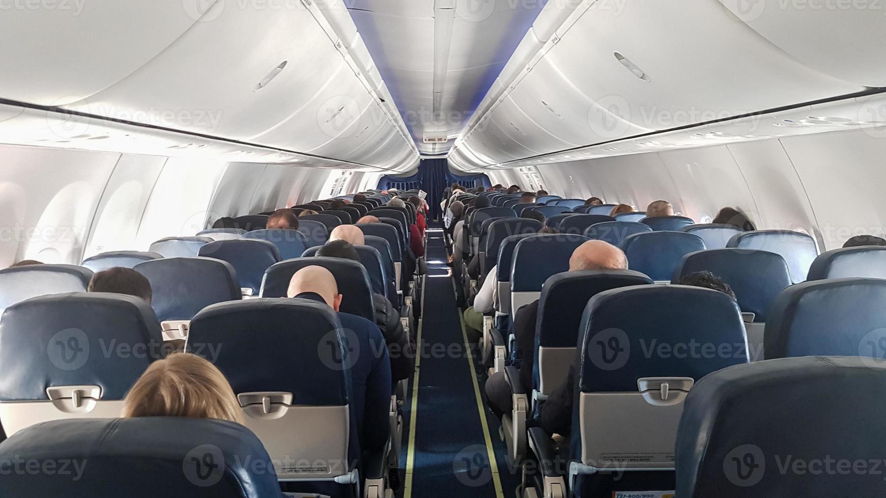 Passengers are waiting for the departure of an Aeroflot flight on a Boeing aircraft before the intercontinental flight. Tourists traveling by plane shot from inside the plane photo