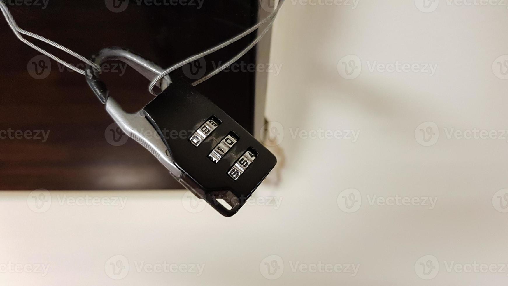 Close-up small combination lock closes electrical panel with black glass cover in office building corridor photo