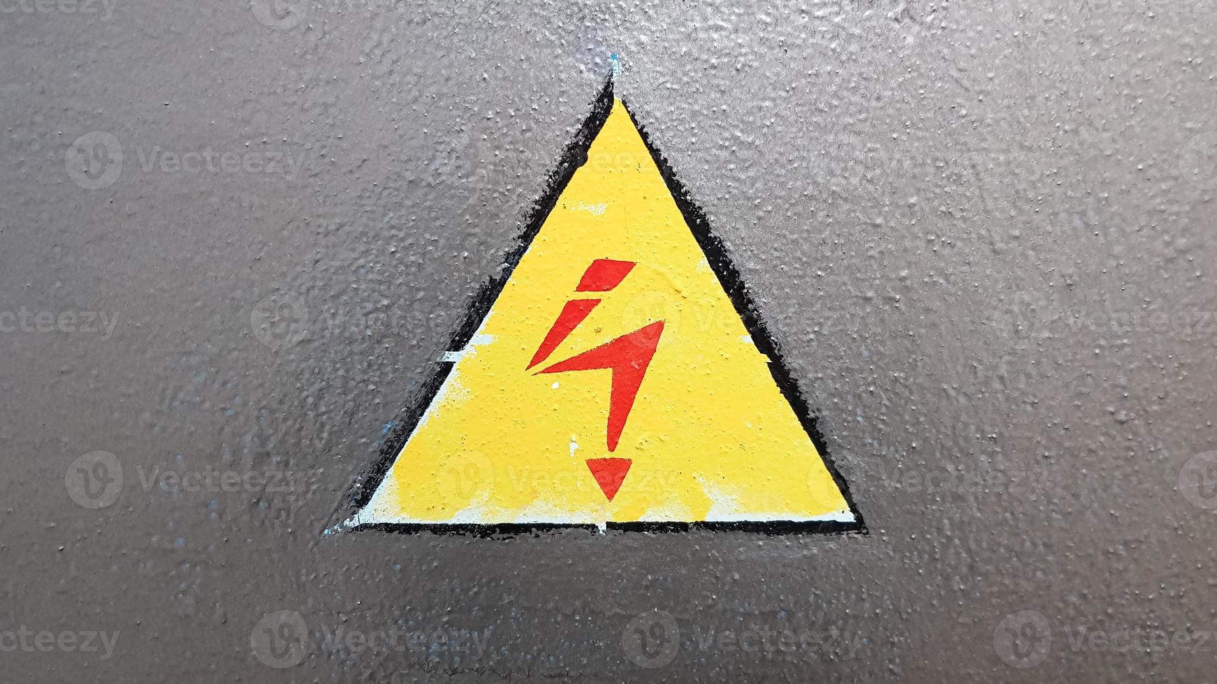 señal de seguridad amarillo y rojo sobre un fondo de metal plateado. relámpago de alto voltaje en un triángulo precaución precaución peligro electricidad muerte. foto