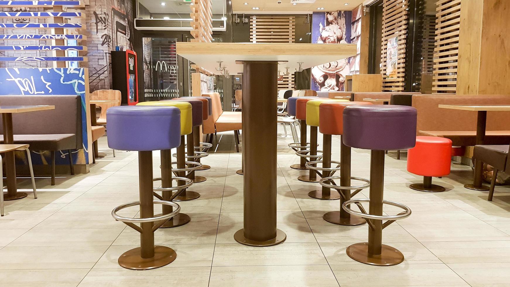 ucrania, kiev - 19 de agosto de 2019. interior del restaurante mcdonald's. mcdonald's es la cadena de restaurantes de comida rápida más grande del mundo con sede en EE. UU. interior con mesas altas y taburetes de bar de colores foto