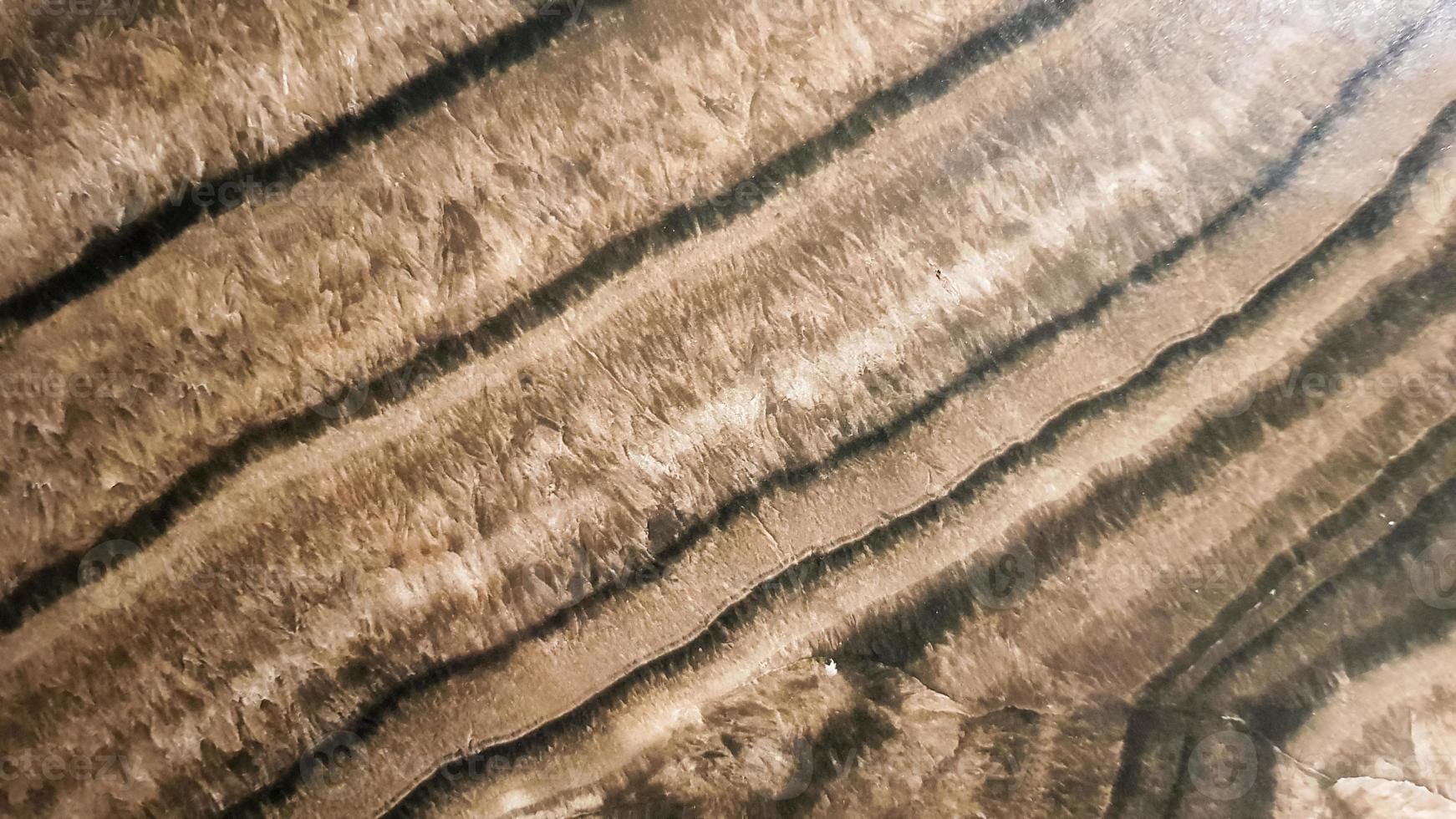 The surface of Sandstone with wavy brown veins. Sulphide agate texture. Wide image of brown natural stone texture Sphalerite. Beautiful wavy pattern of cut of Schalenblende stone close-up photo