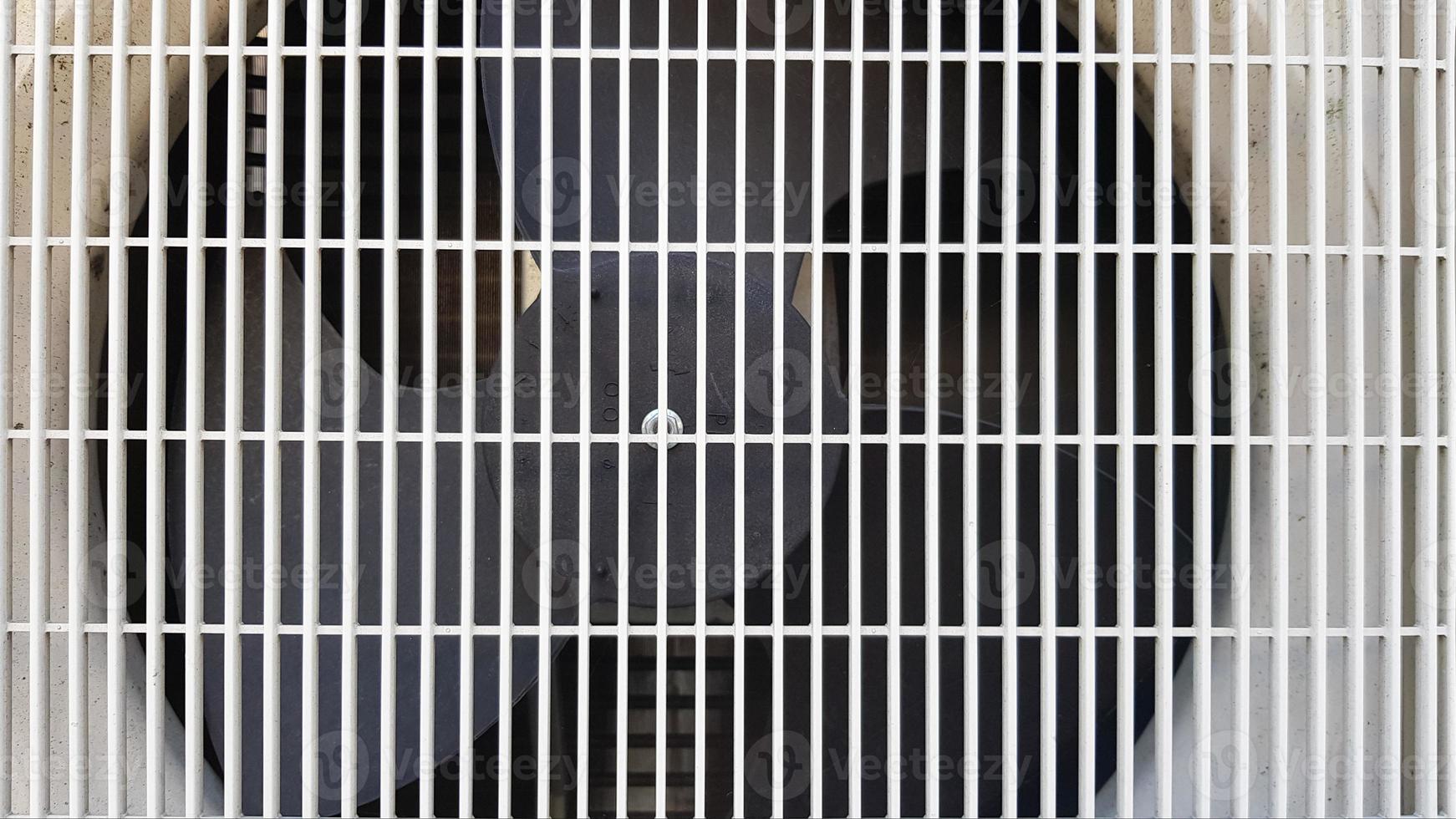 Close up image of an old industrial air conditioner condenser unit coil and louver fan for background. photo