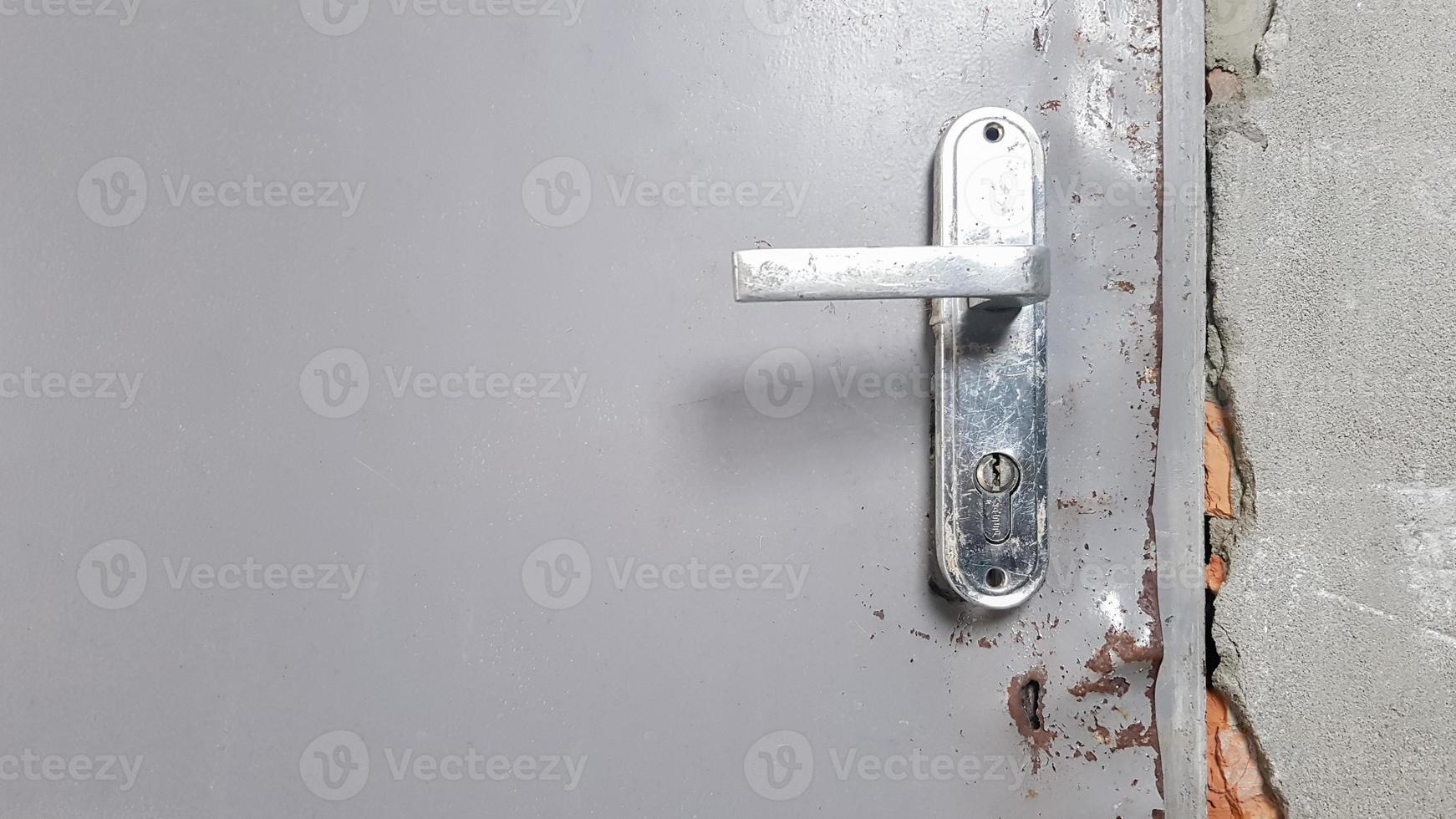 Old metal doorknob on an old door. Rust on the doorknob. photo