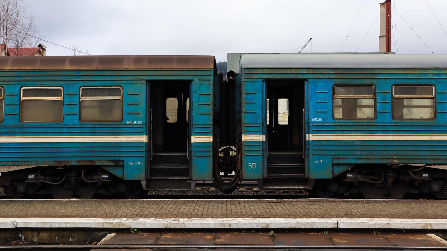 Ucrania, Yaremche - 20 de noviembre de 2019. Tren en la estación sobre un fondo de montañas. vagones de ferrocarril únicos en el andén de la ciudad de yaremche. Antiguo tren de pasajeros diesel. estación de ferrocarril. foto