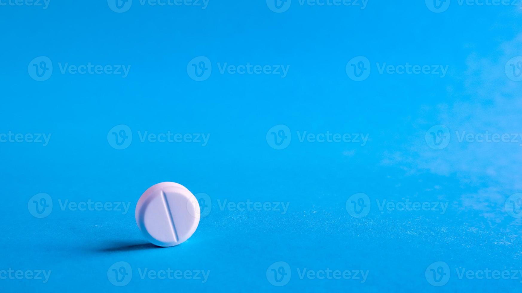 Pastillas médicas redondas blancas sobre un fondo azul. Pastillas blancas esparcidas sobre la mesa. el concepto de medicina, farmacia y salud. Copie el espacio espacio vacío para texto o logotipo. foto