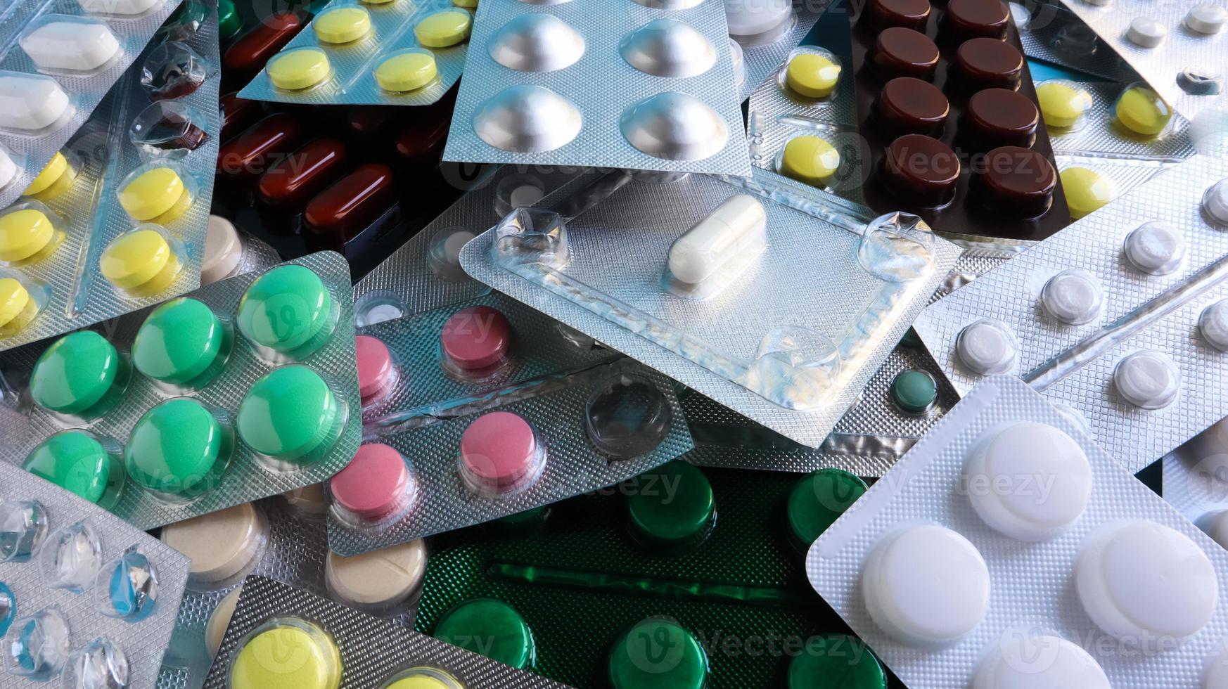 Pills, capsules with medicine, vitamins in the package, in blister packs are on the table. antibiotics, multicolor antibacterial drugs. Healthcare and medicine concept. Copy space. photo