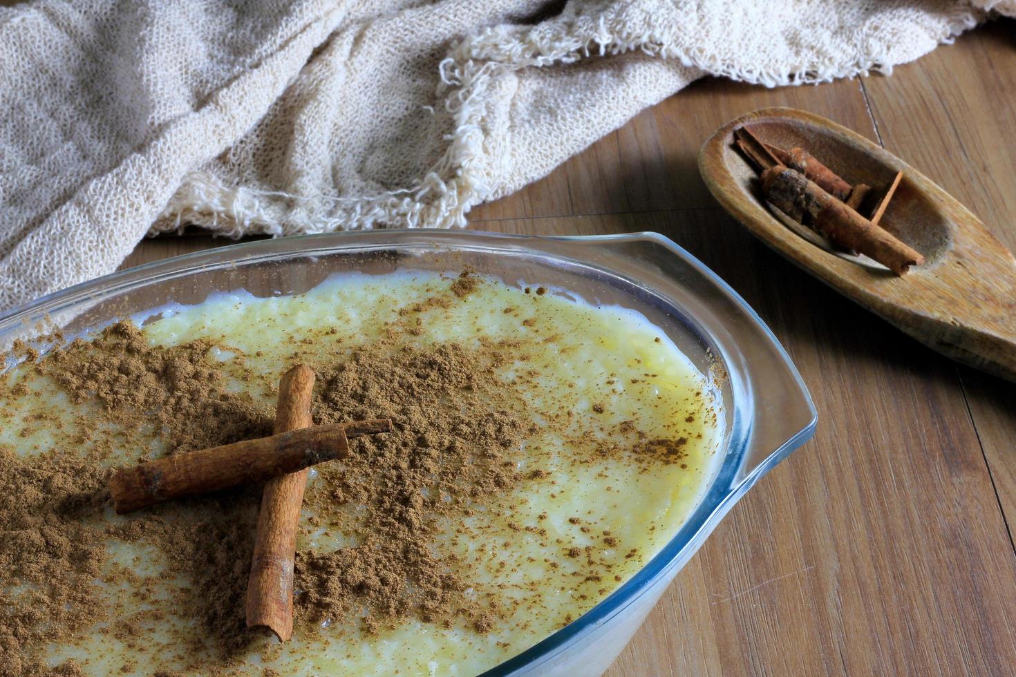 rice pudding with cinnamon in glass container, contoured by fabric photo