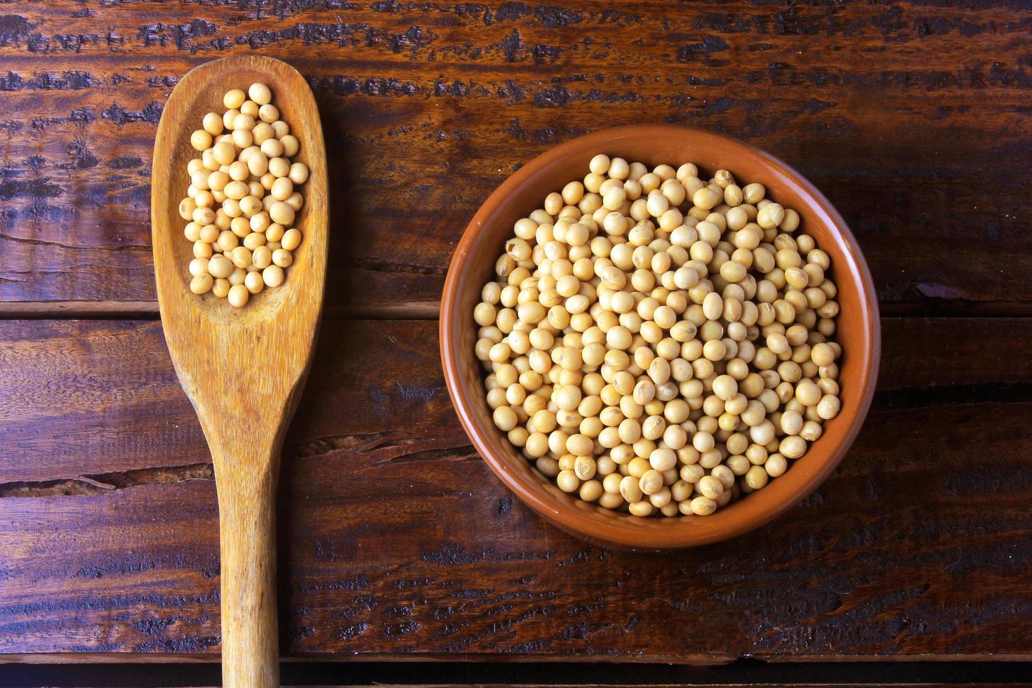 raw and fresh soy beans inside white ceramic bowl on rustic wooden table. Close up photo