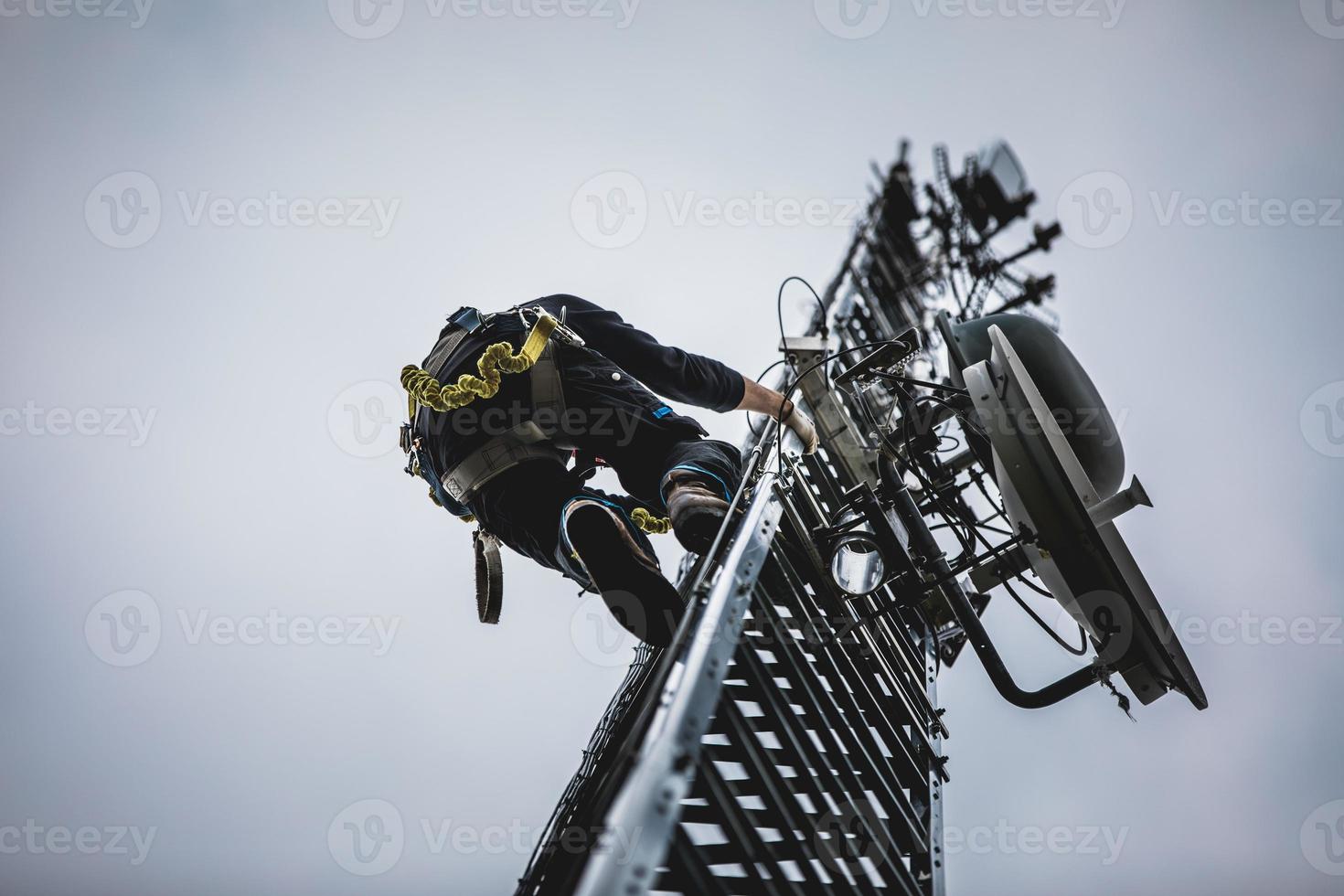 Telecom Worker Climbing Antenna Tower photo