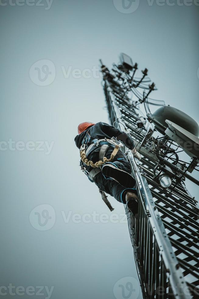 Telecom Worker Climbing Antenna Tower photo