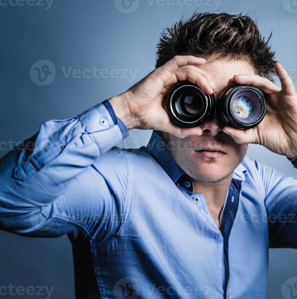 Photographer Looking Through Lenses in Studio photo