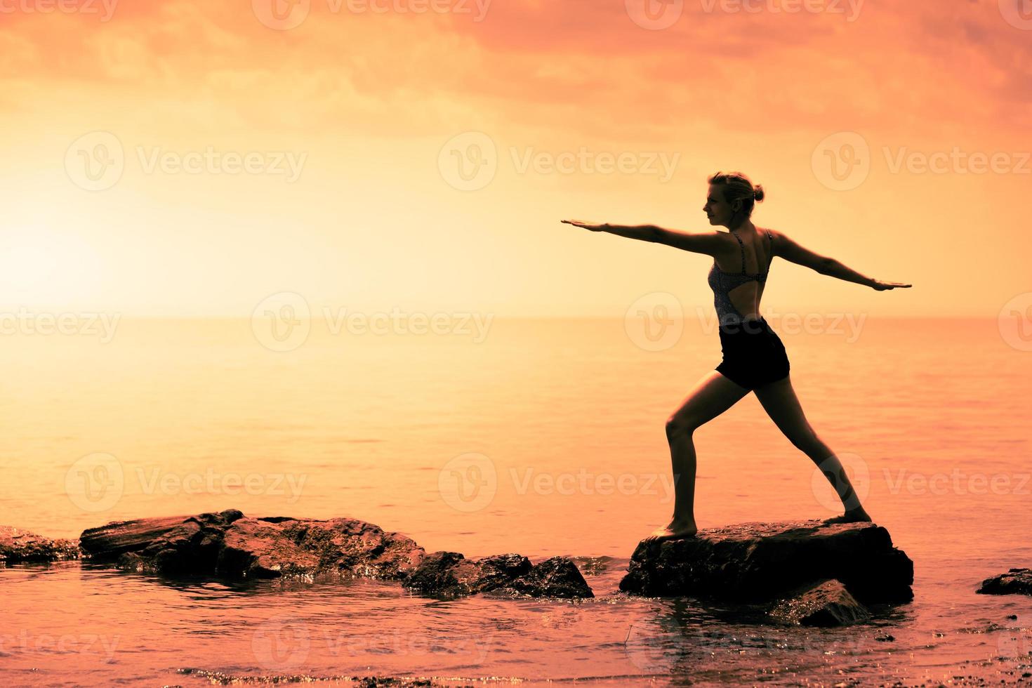 Young Woman doing the Warrior Yoga Position in Front of the Ocean photo