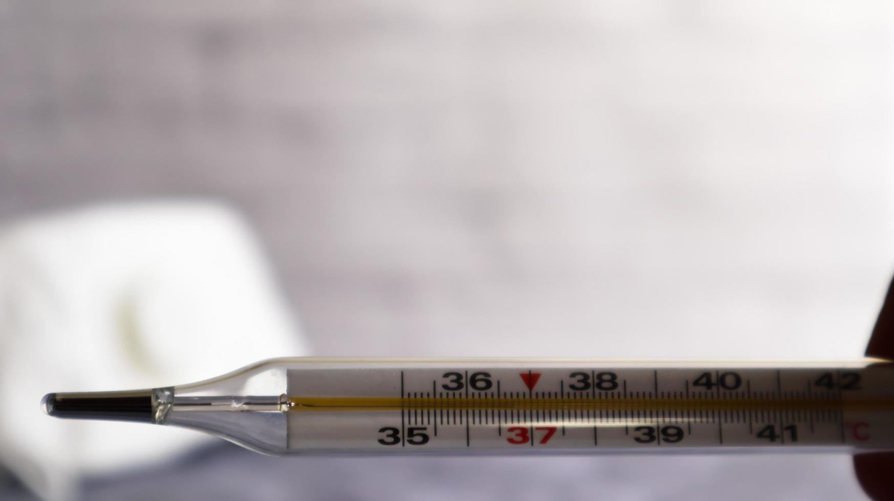 Coronavirus medical mask and thermometer for measuring temperature. respiratory bandage for the face. checking body temperature for viral symptoms - concept of an epidemic viral epidemic photo