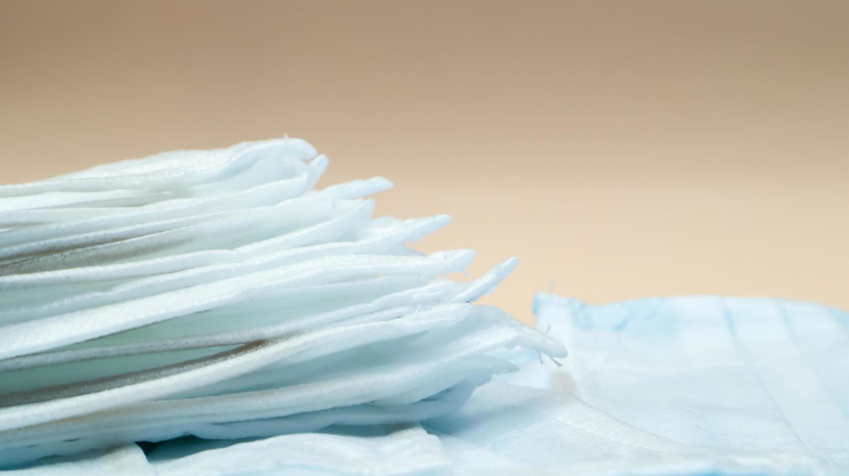 Coronavirus protection. Antiviral protective medical face masks with ear loops. Surgical mask background. Respiratory syndrome, coronavirus disease COVID-19. Many folded medical masks. photo