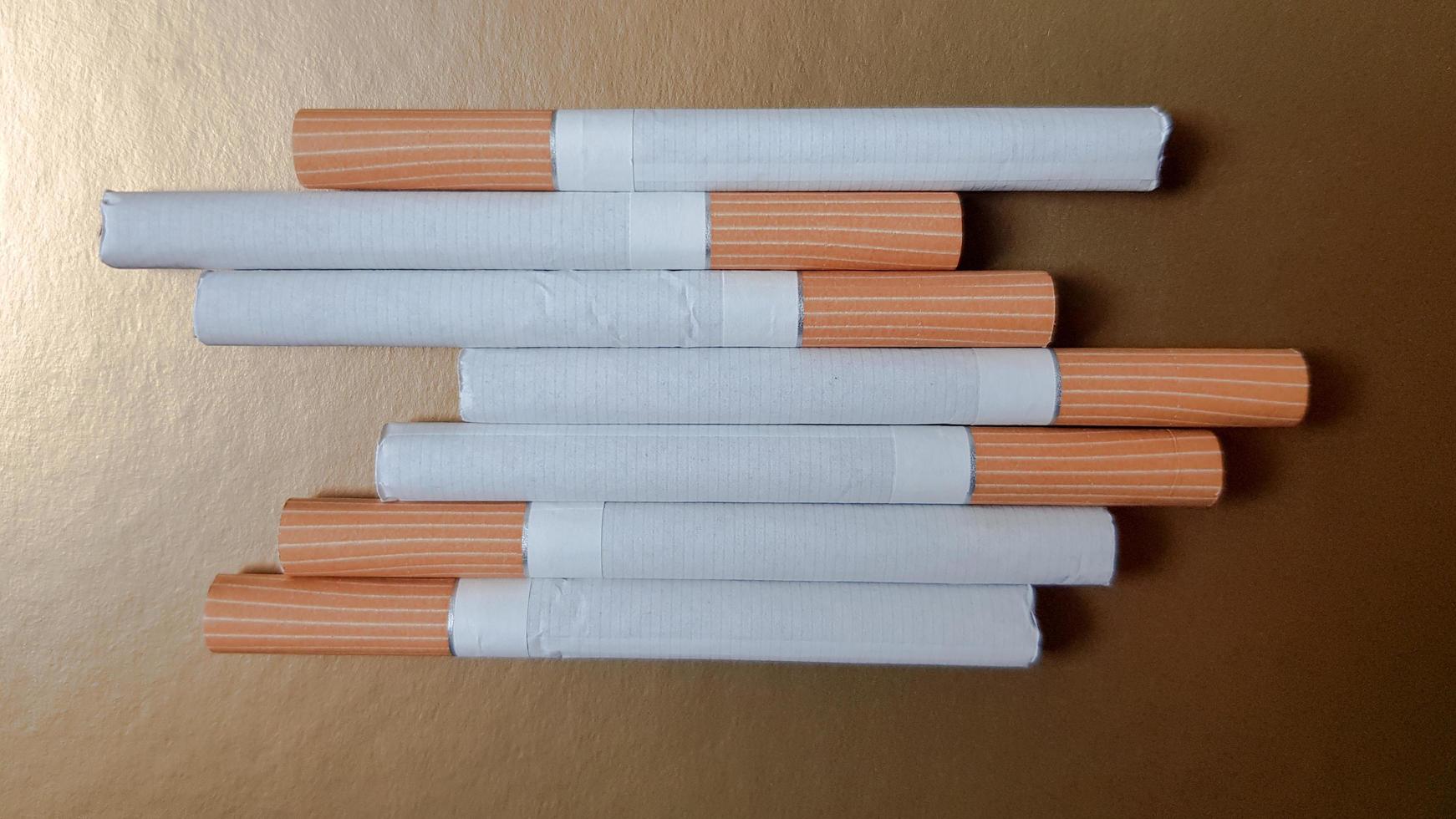 Image of several commercial cigarettes. pile of cigarettes on a gold background or concept of anti-smoking campaign, tobacco photo