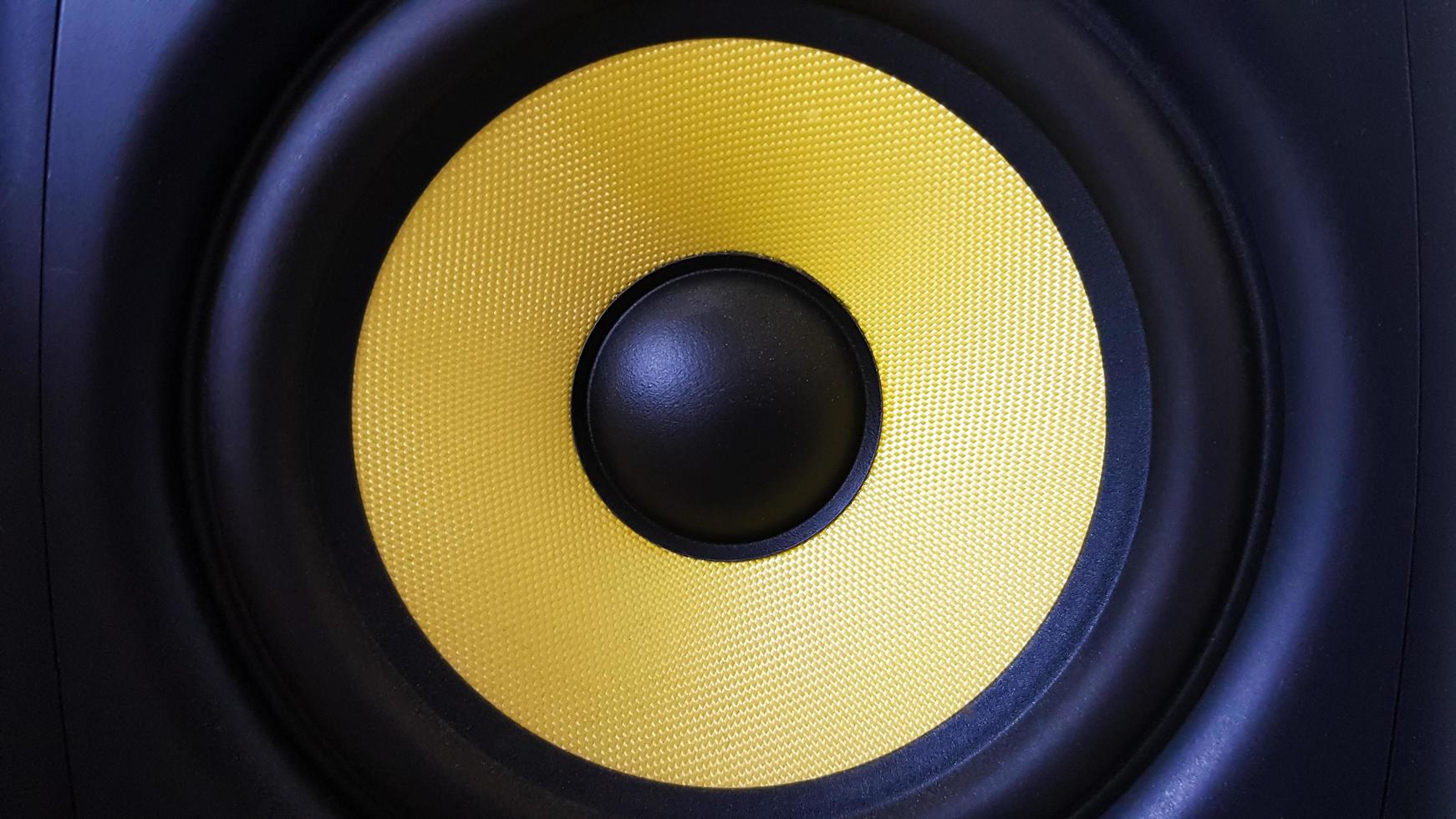 fondo del altavoz. woofer, primer plano del subwoofer amarillo. equipo de estudio profesional. monitor vocal para mezclar y grabar música. monitores de escritorio de alta calidad. foto