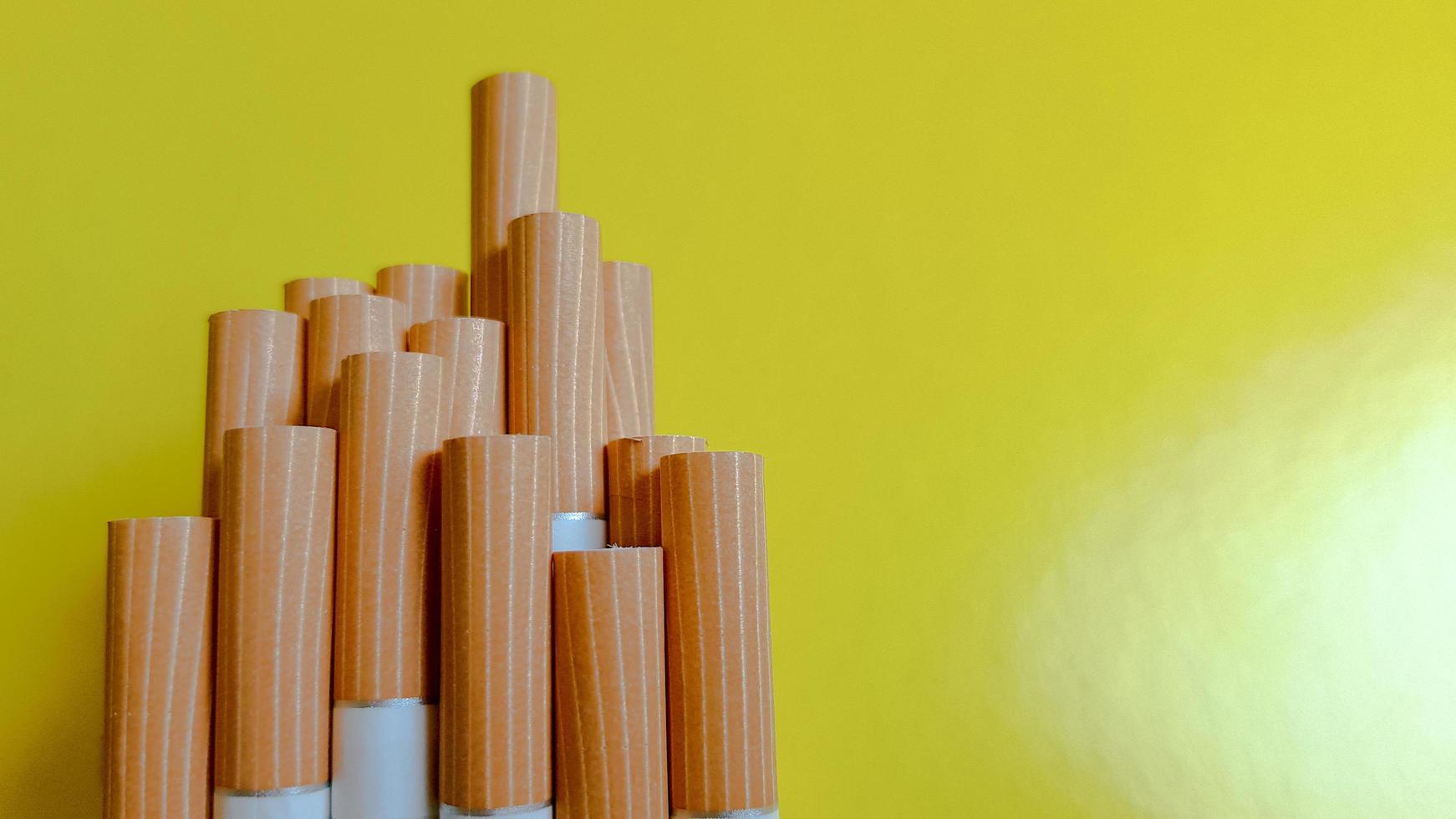 Make a cigarette. Photo of cigarette yellow filters on a yellow background. Natural light