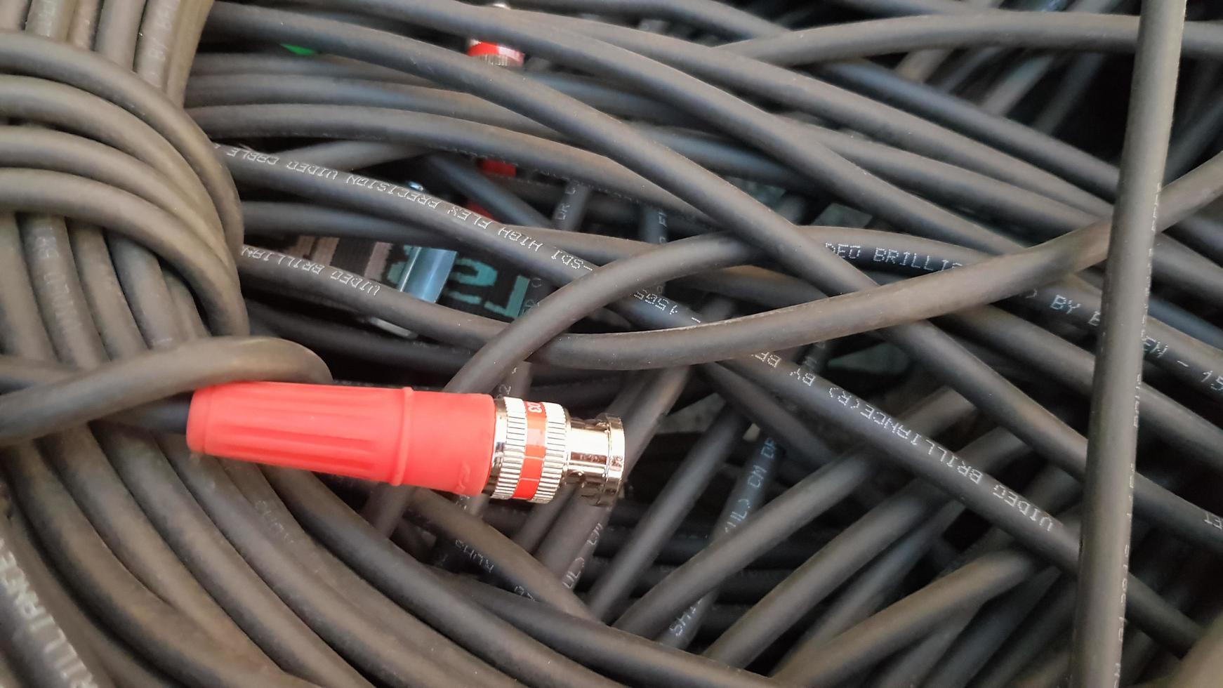 un rollo de primer plano de cable negro con un enchufe rojo. foto
