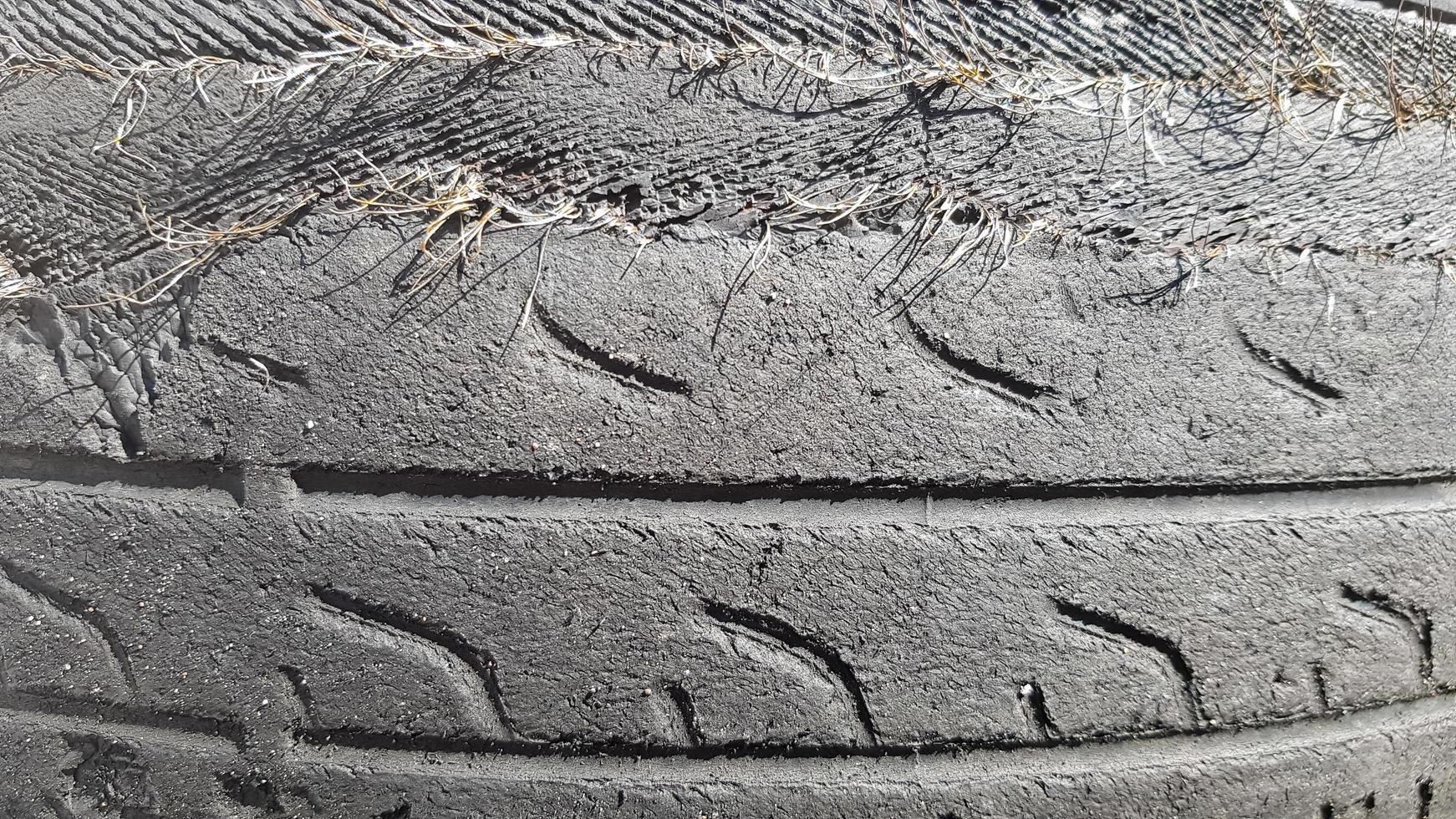 A tire that is damaged after prolonged use. A worn-out and torn car tire in a junkyard. photo