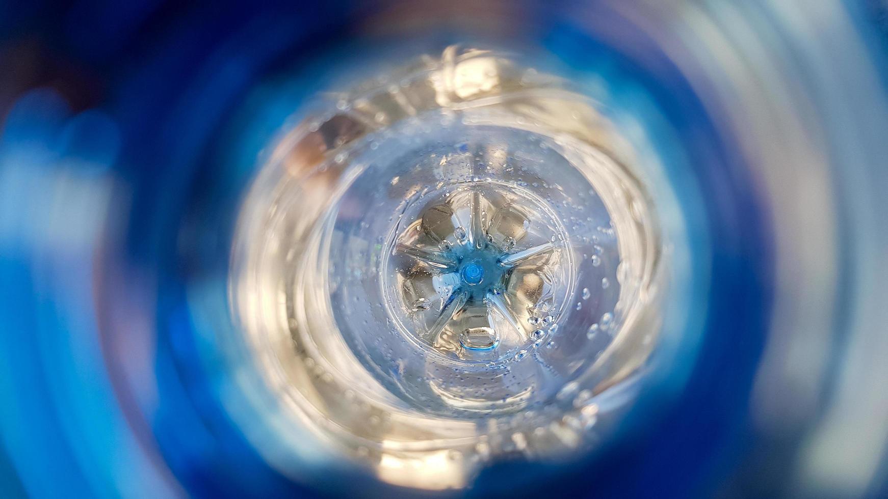 Long background with a plastic blue bottle with water drops inside photo