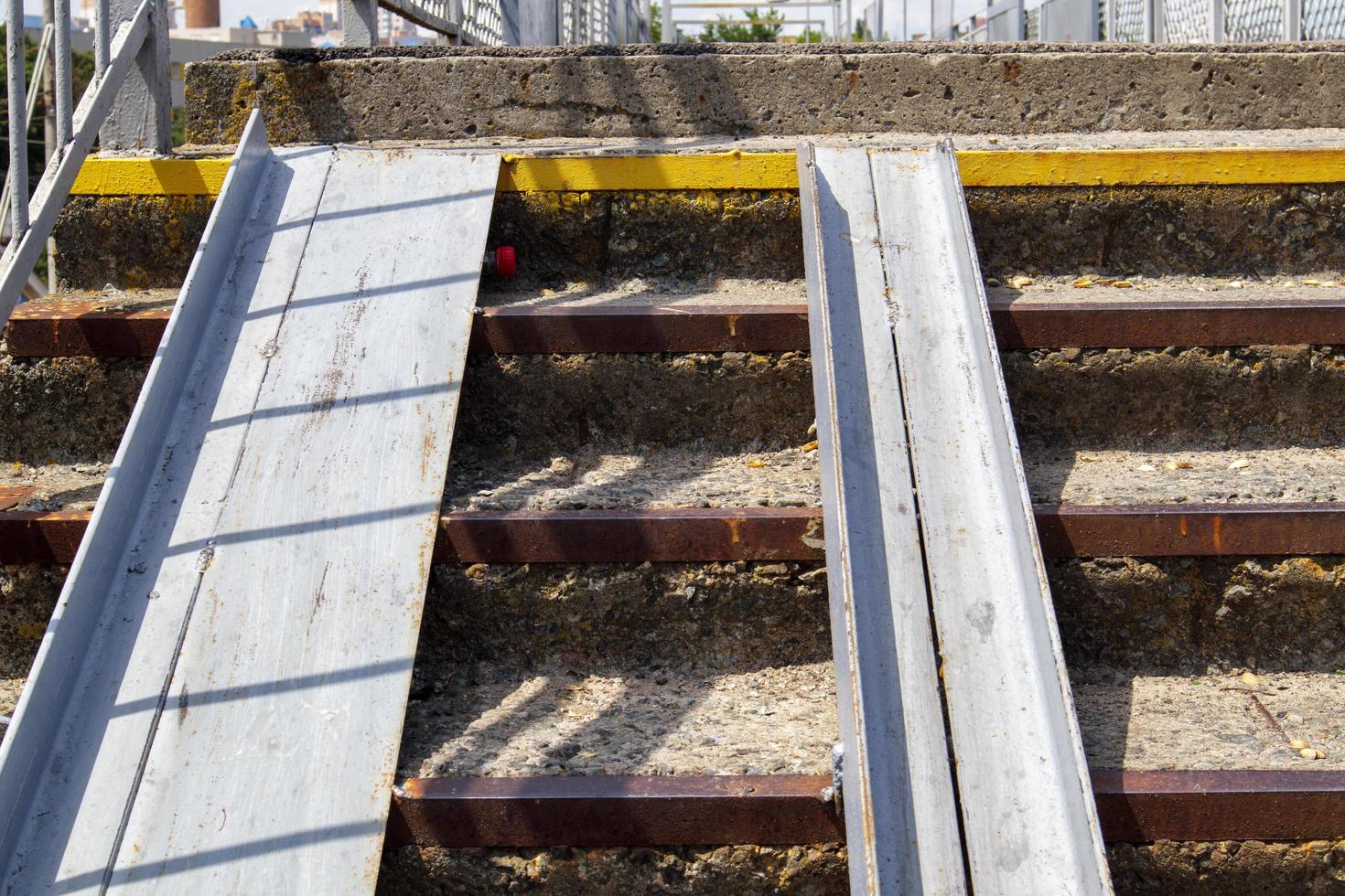 The staircase of the pedestrian crossing with traces of destruction. Two wheelchair rails. Metal railings for bicycles, wheelchairs and strollers with children. Special equipment on the stairs. photo