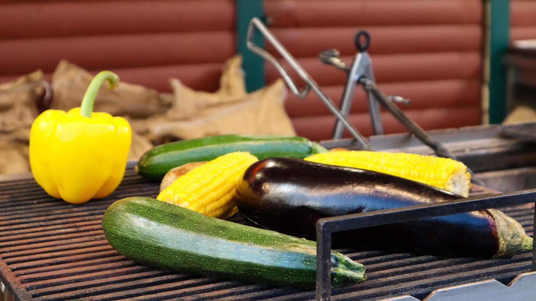 Grilling vegetables during an outdoor barbecue or on a picnic. Man preparing a vegetable barbecue, during summer time, direct sun light background. Summer feeling. Smoked vegan appetizer appetizer. photo