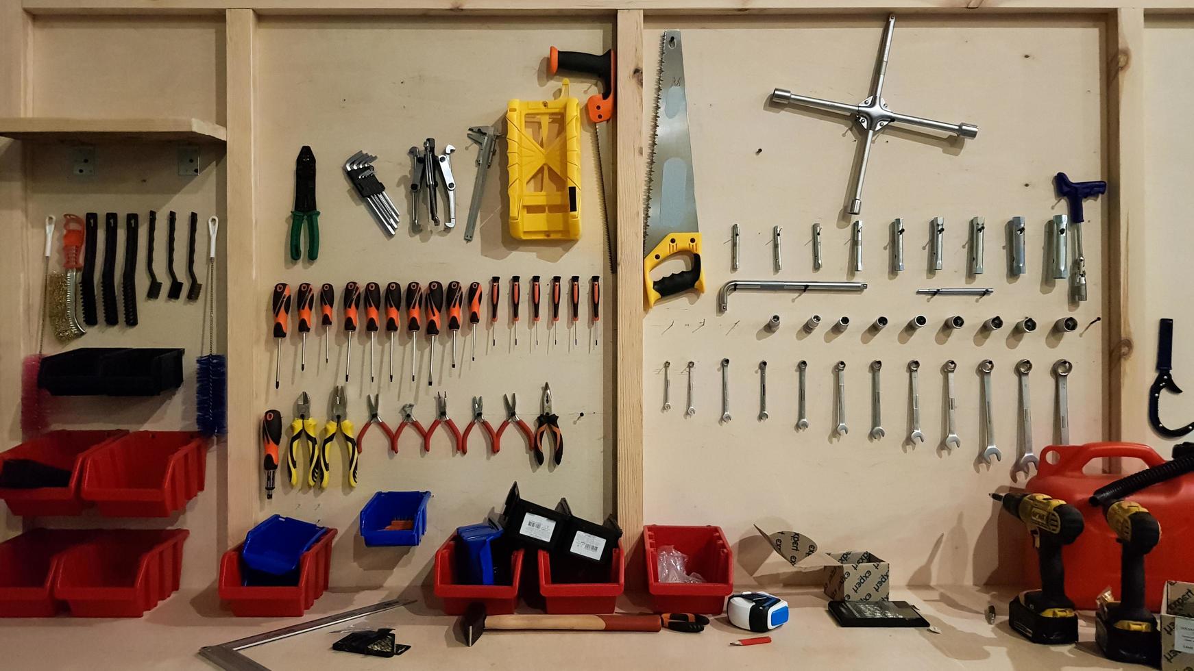 Ukraine, Kiev - May 09, 2020. Work tools on the board and in the workshop. Workshop scene. A lot of old tools on a dirty desktop. The concept of carpentry and painting. photo