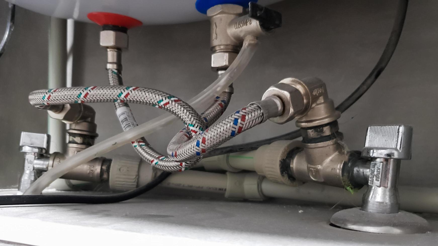 Connection of water supply, hot and cold water to the boiler. Hose for hot and cold water in the bathroom. Plumbing connections for a domestic electric water heater. photo