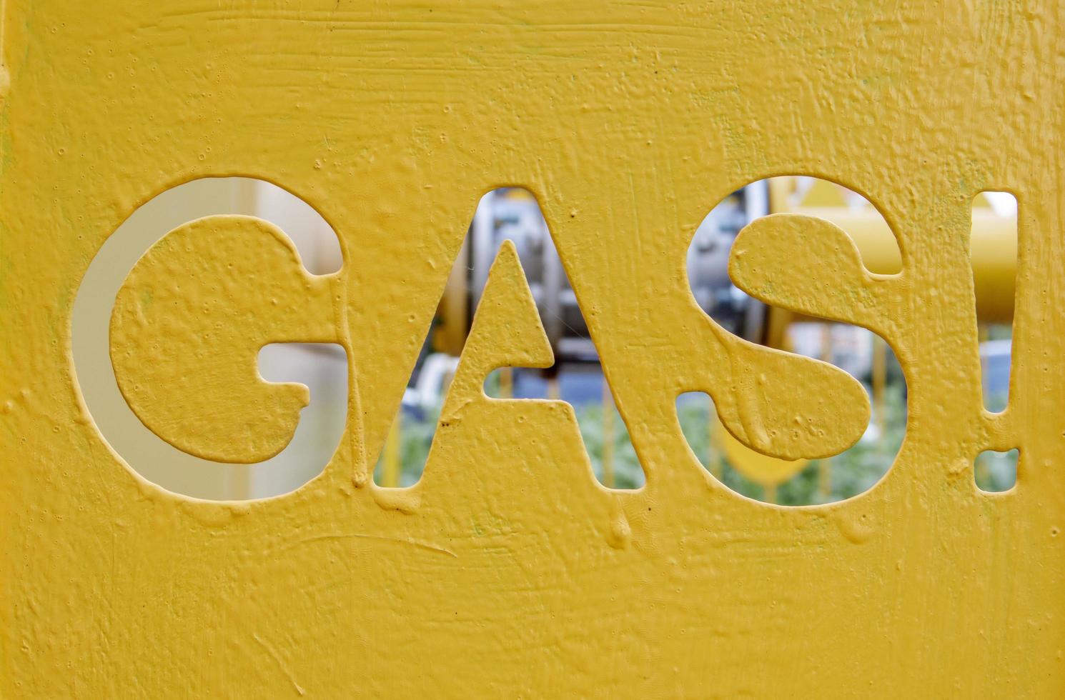 Warning on a metal cage with gas equipment for the public. Attention gas pipe. The inscription in English GAZ. A yellow warning sign for a medium pressure gas pipeline on a surface installation. photo