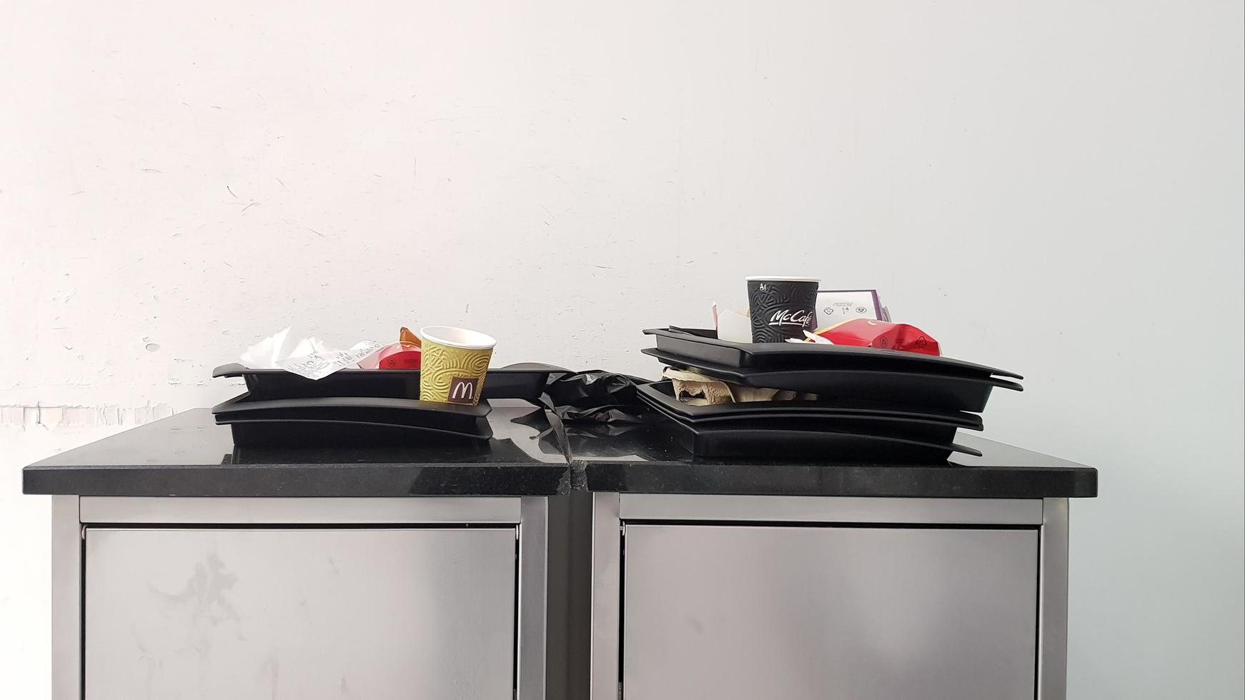 Ukraine, Kiev - March 06, 2020. The concept of cleanliness and cleaning rules. At the exit of fast food, a McDonald's trash can with trays. photo