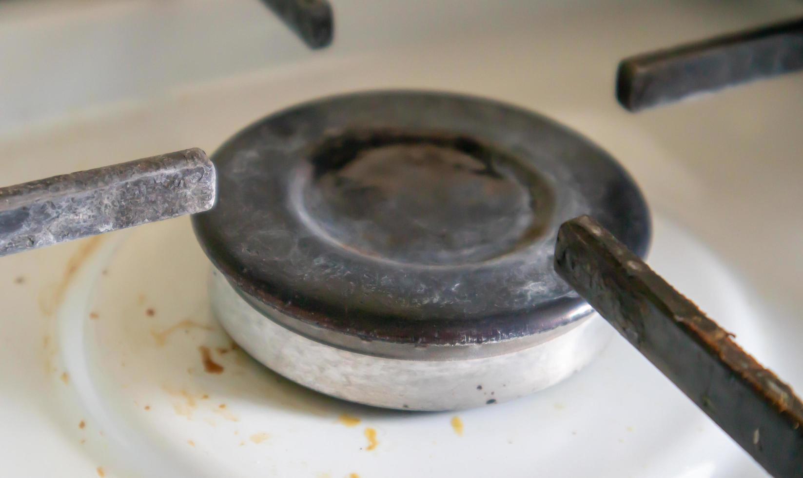 Dirty gas stove in the kitchen for cooking with vegetable oil stains and burnt food debris on the surface, close-up. Selective focus. Grease-covered gas hob in the kitchen. photo