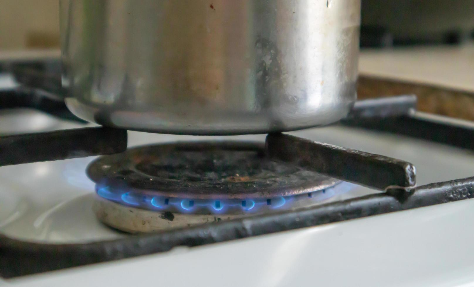 Estufa de gas sucia en la cocina para cocinar con manchas de aceite vegetal y restos de comida quemados en la superficie, primer plano. enfoque selectivo. Encimera de gas engrasada en la cocina. gas incluido. foto