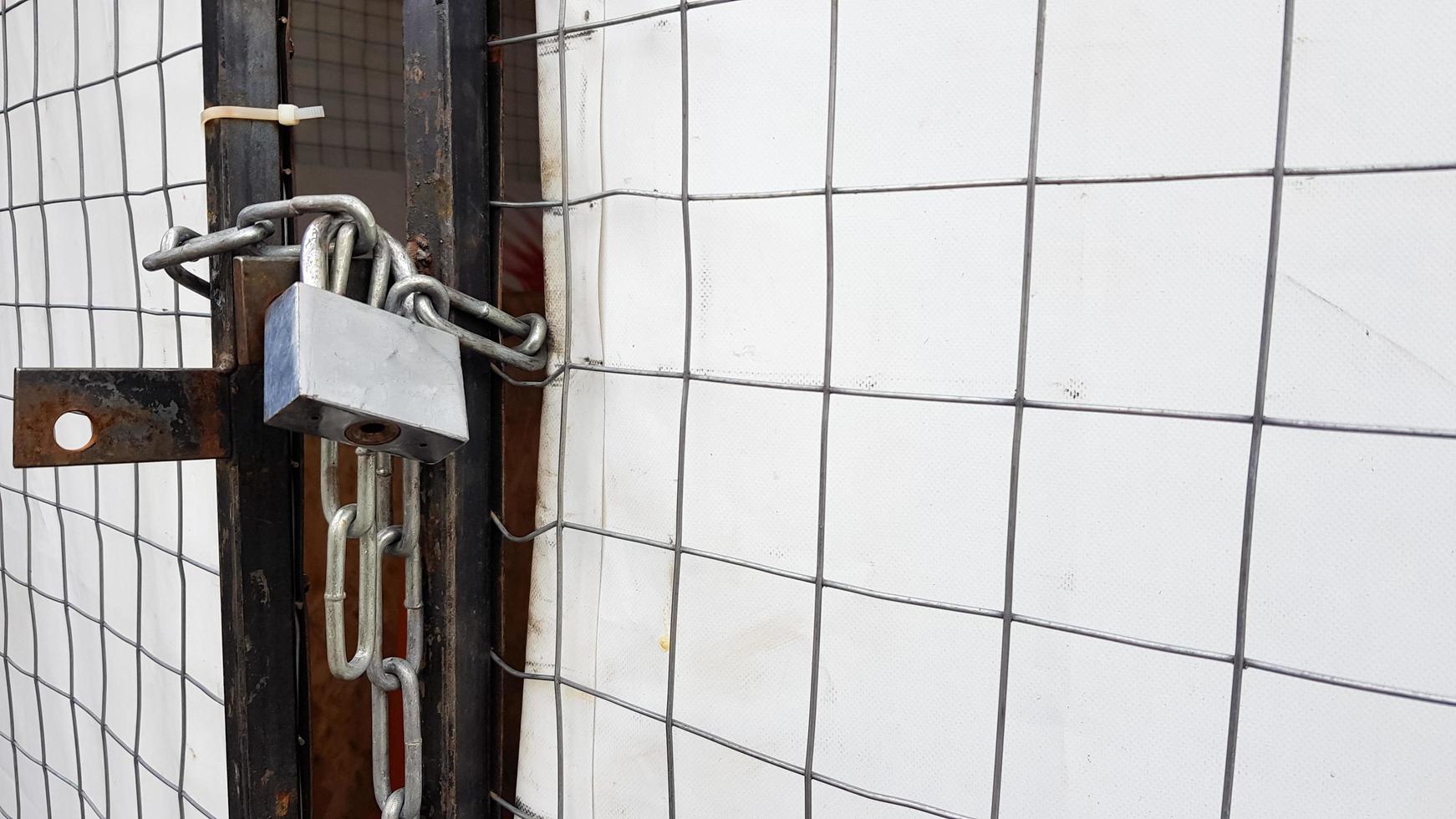 Closed padlock on a hangar from a grid and a white banner photo