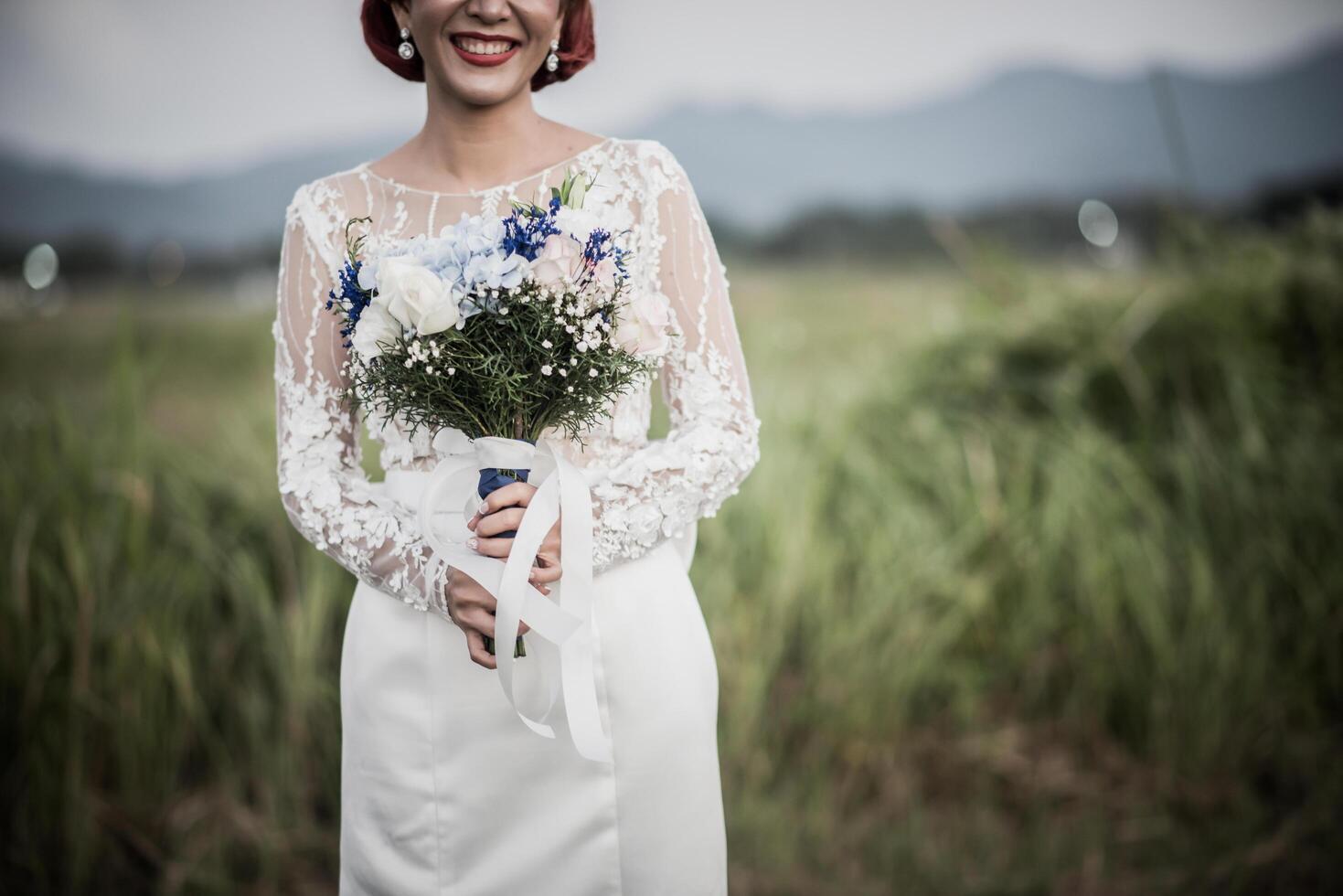 mano de la novia sosteniendo la flor en el día de la boda foto