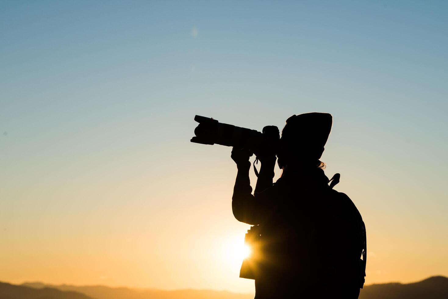 Silhouette of tourist woman standing in the mountain photo