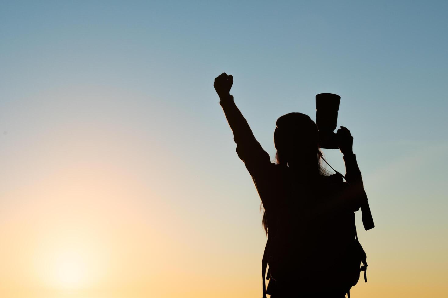 Silhouette of tourist woman standing in the mountain photo