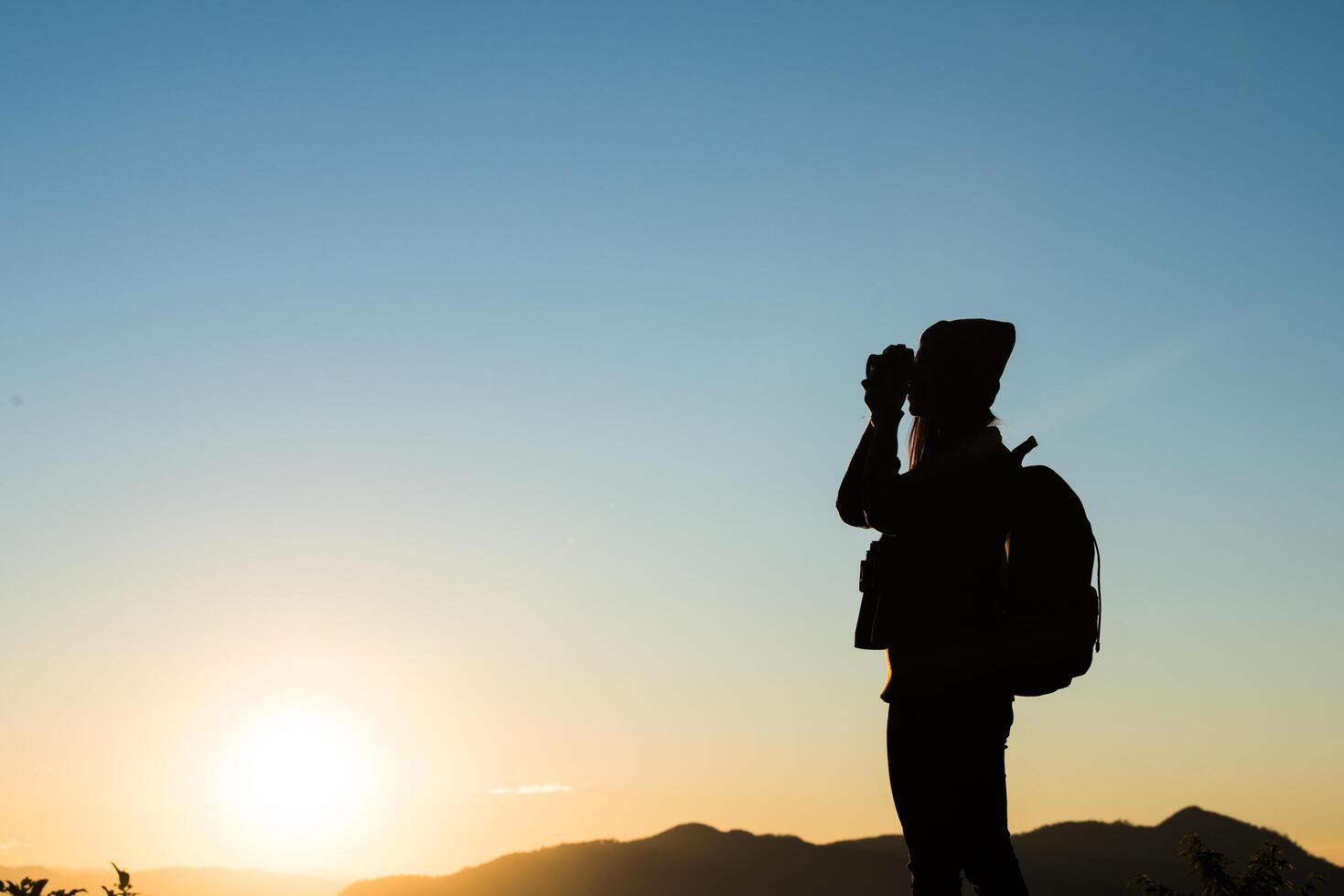 Silhouette of tourist woman standing in the mountain photo