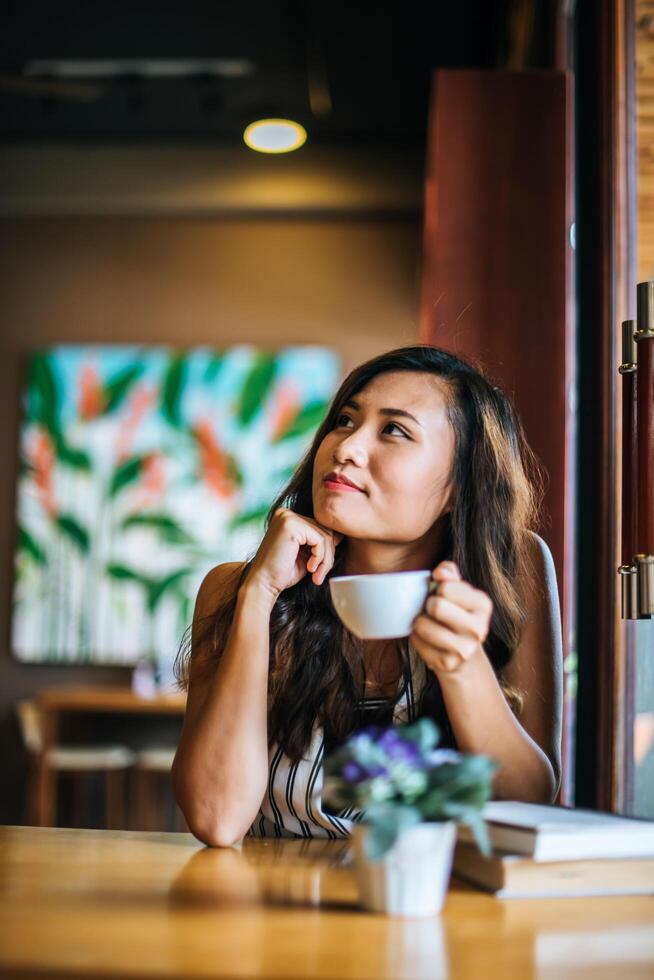 retrato, mujer asiática, sonriente, relajarse, en, cafetería, café foto