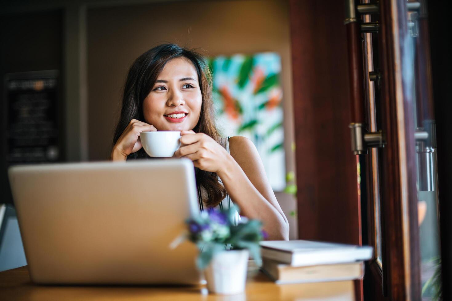 Beautiful woman working with laptop computer at coffee shop cafe photo