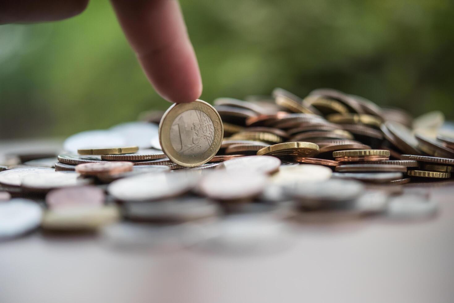 concepto de ahorro de dinero. mano poniendo dinero pila de monedas foto