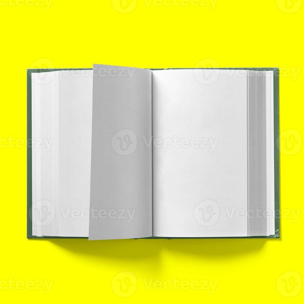 Back to school concept , hard cover dark green book middle turning isolated on yellow. photo