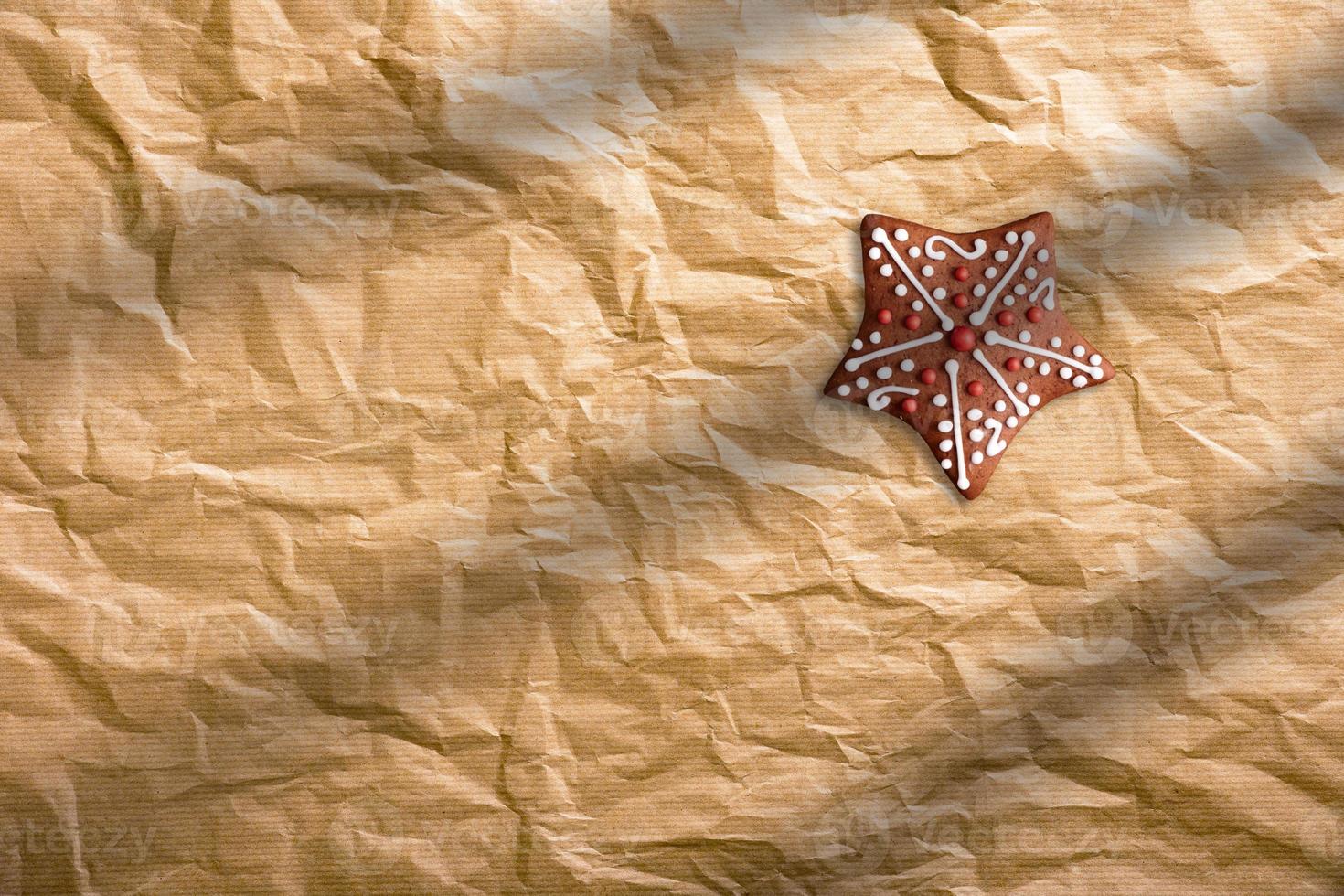 Close up of Christmas gingerbread cookie on brown paper background. photo