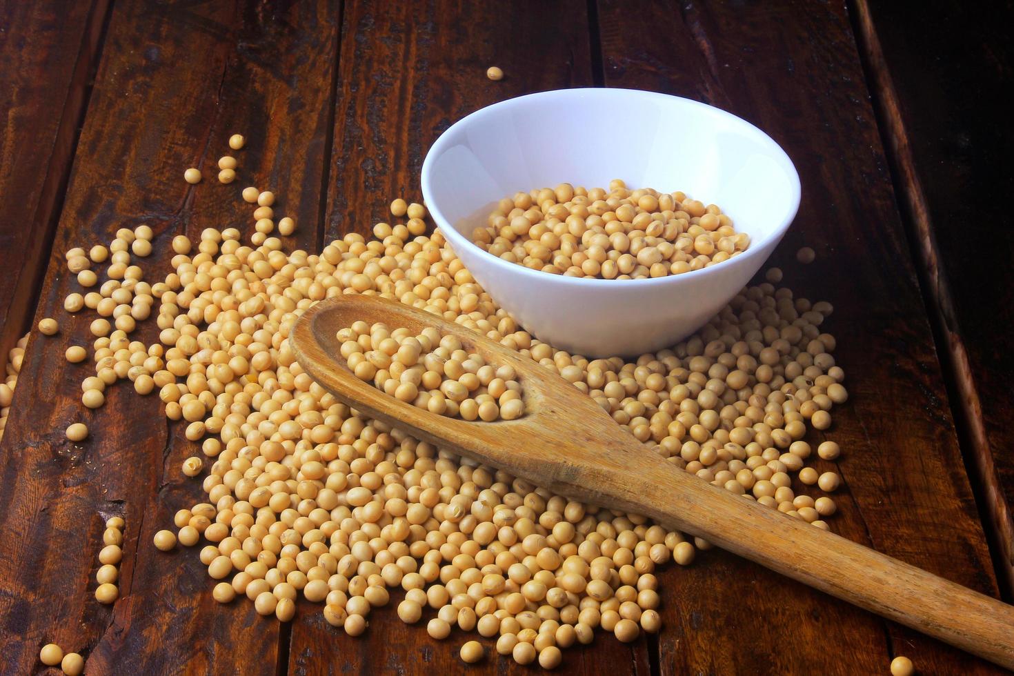 raw and fresh soy beans inside white ceramic bowl on rustic wooden table. Close up photo