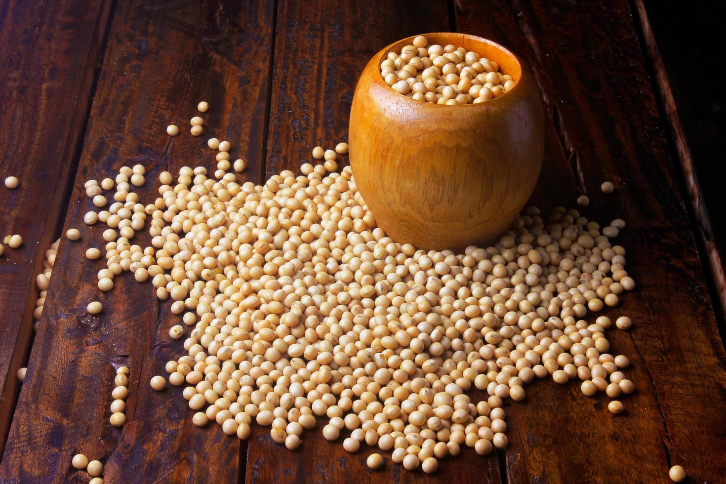 raw and fresh soy beans inside wooden bowl on rustic wooden table. Closeup photo